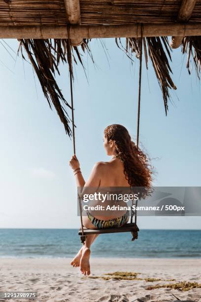 young woman on tropical swing at the beach,canoas de punta sal,peru - rope swing stock pictures, royalty-free photos & images