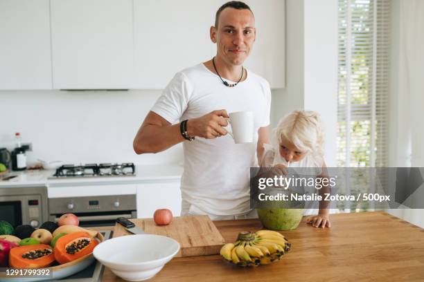 a father with his daughter having breakfast in kitchen,ko pha ngan,thailand - 2 coconut drinks ストックフォトと画像