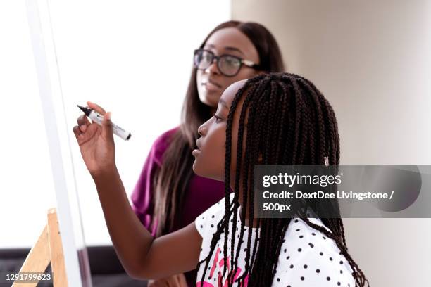 african mother teaching daughter at home,east legon,accra,ghana - ghanaian family stock pictures, royalty-free photos & images