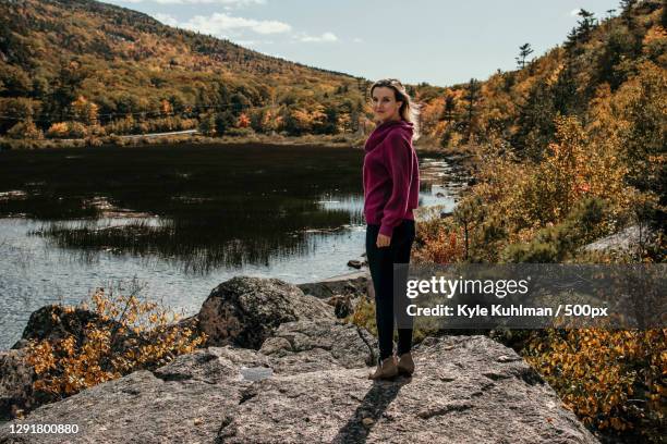 full length of woman standing on rock by lake against mountains,boston,massachusetts,united states,usa - boston women ストックフォトと画像