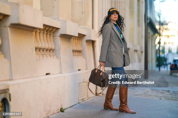 Gabriella Berdugo wears a Steelers cap hat, vintage mom denim blue jeans, a Maison Père "Message" hoodie sweater, a vintage checked print beige...