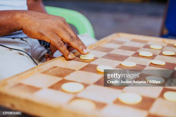 midsection of young man playing checkers outdoors,tema,ghana - checkers game ストックフォトと画像