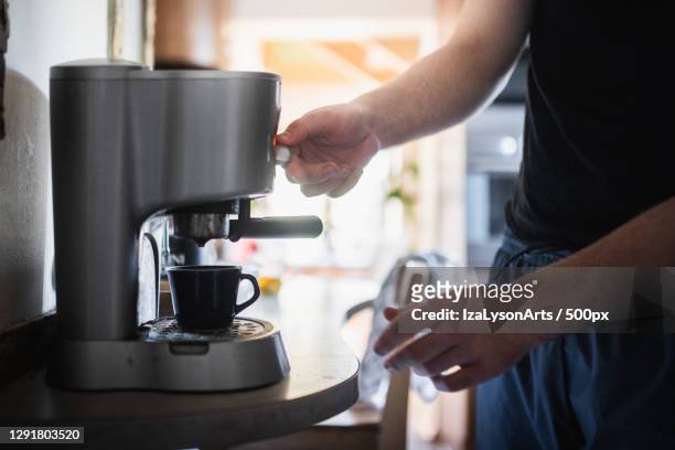 midsection of man preparing coffee at home,poland - coffee maker - fotografias e filmes do acervo