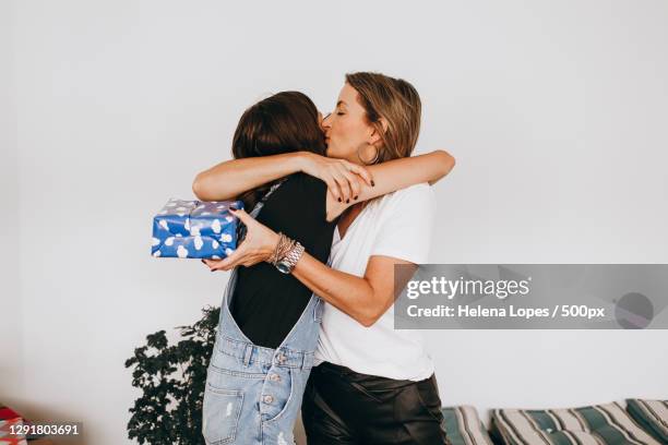 mother and teenage daughter hugging during holiday gift exchange,belo horizonte,state of minas gerais,brazil - exchanging gifts stock pictures, royalty-free photos & images
