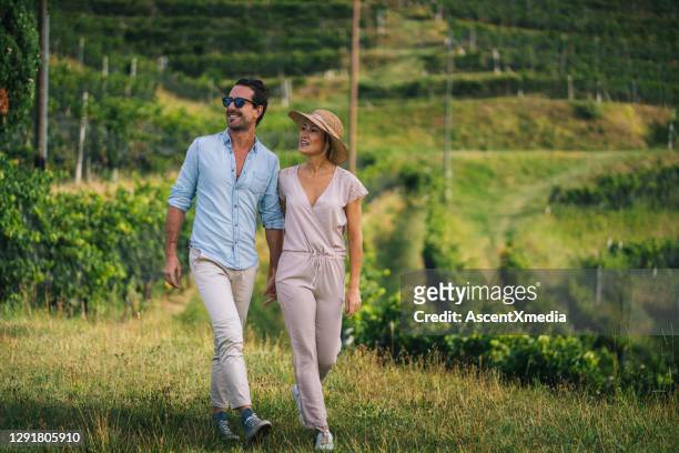 couple walk through vineyard in the morning - calças verdes imagens e fotografias de stock