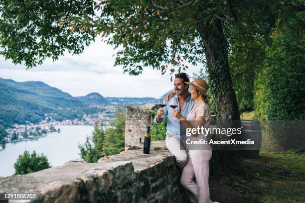 het paar geniet van wat rode wijn in italiaanse wijngaard - lago maggiore stockfoto's en -beelden