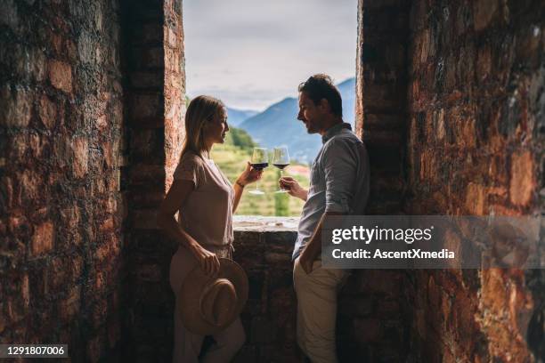 het paar geniet van wat rode wijn in oud italiaans kasteel - romantic holiday stockfoto's en -beelden