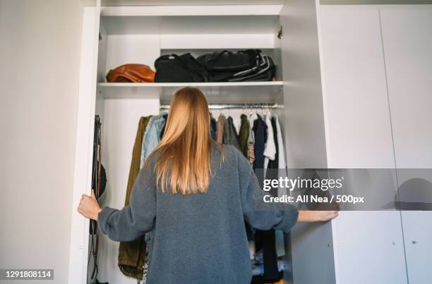 caucasian woman organizing closet at home,spain - neat stockfoto's en -beelden