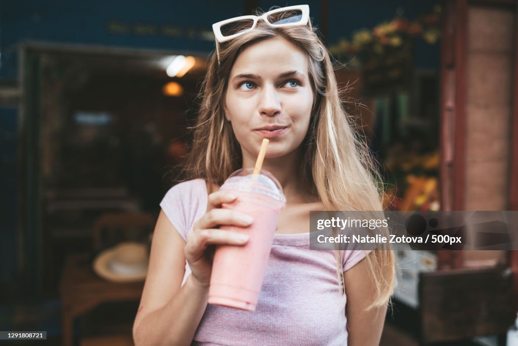 Young blonde woman drinking strawberry smoothie,Chiang Mai,Thailand