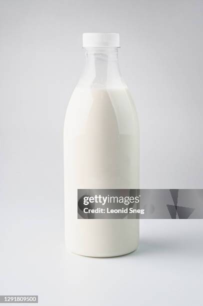 food photography of clean white sterile plastic bottle of natural milk front view on a light gray background isolated close up - milk bottle photos et images de collection