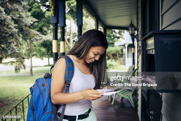 teenage girl receiving letter of acceptance for college in mail - college acceptance letter stock pictures, royalty-free photos & images