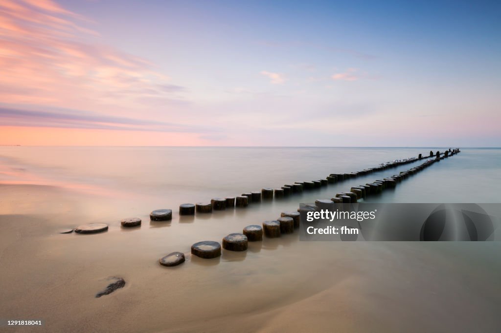 Groynes on the beach at sunset