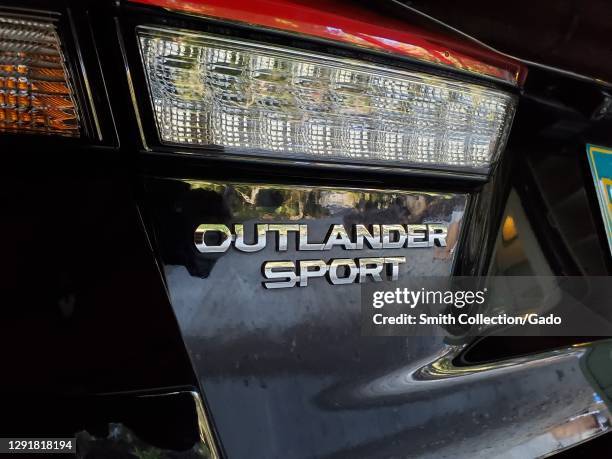 Close-up shot of Mitsubishi Motor's Outlander Sport logo placed below the back light of an SUV in Lafayette, California, November 30, 2020.