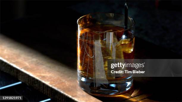 classic prohibition manhattan cocktail in old fashioned rocks glass being stirred - rye new york stock pictures, royalty-free photos & images