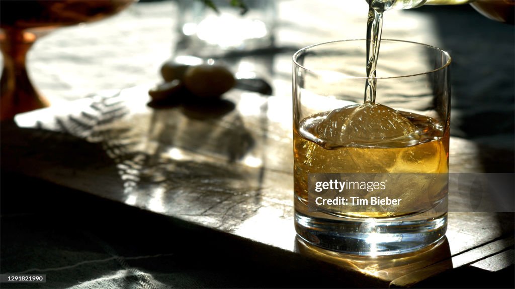 Classic Prohibition Manhattan Cocktail in Old Fashioned Rocks Glass being poured.