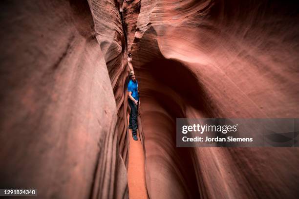 a man hiking through spooky gulch, a narrow slot canyon in southern utah. - narrow stockfoto's en -beelden