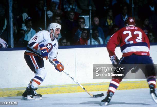 Bryan Trottier of the New York Islanders looks to pass the puck as Bobby Gould of the Washington Capitals charges in during their game on November 4,...