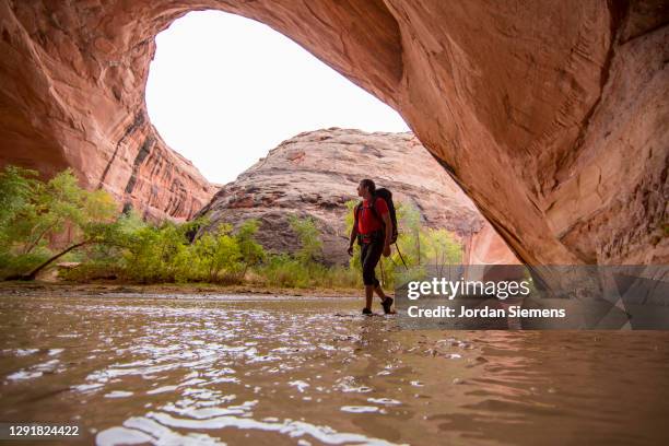 a man hiking beneath jacob hamblin arch - 33 arches stock pictures, royalty-free photos & images