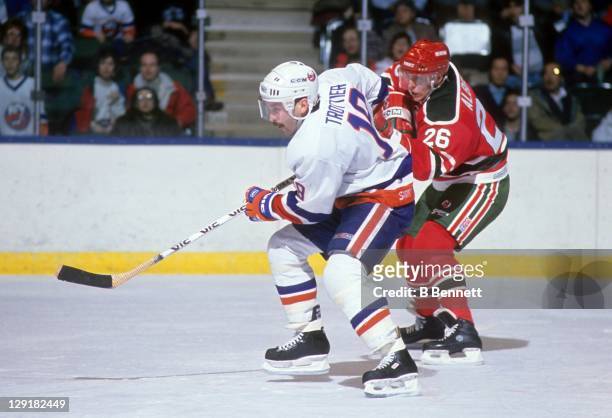 Bryan Trottier of the New York Islanders and Tommy Albelin of the New Jersey Devils go for the puck during their game on December 17, 1988 at the...
