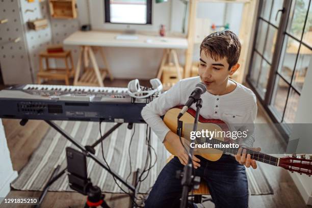 teenager junge singen und gitarre spielen in musik-telekonferenz - boy singing stock-fotos und bilder
