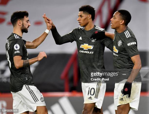 Marcus Rashford of Manchester United celebrates with team mates Bruno Fernandes and Anthony Martial after scoring their sides third goal during the...