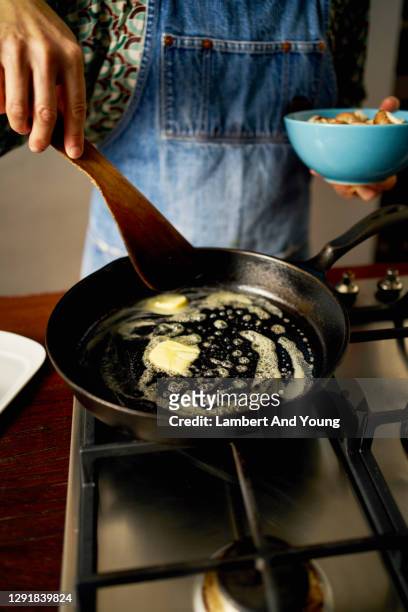 melting butter in a frying pan ready to fry mushrooms - frying pan stock-fotos und bilder