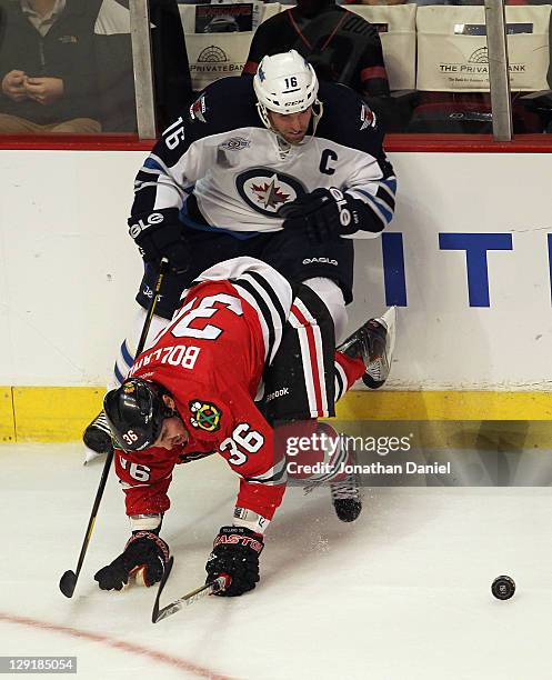 Dave Bolland of the Chicago Blackhawks hits the ice trying to keep the puck away from Andrew Ladd of the Winnipeg Jets at the United Center on...