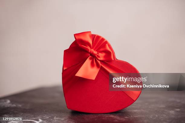 valentine's day, gift box of kraft paper with a red ribbon and candles. rustic style - heart box ribbon stockfoto's en -beelden