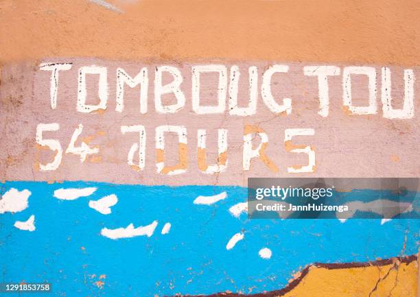 zagora, morocco: colorful wall with old timbuktu road sign - zagora imagens e fotografias de stock