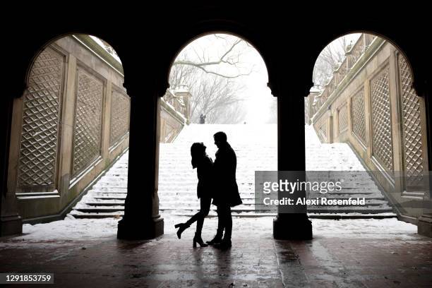 Silhouette of a couple embraces under the Bethesda Terrace, Central Park during a snow storm on December 17, 2020 in New York City. New York City...