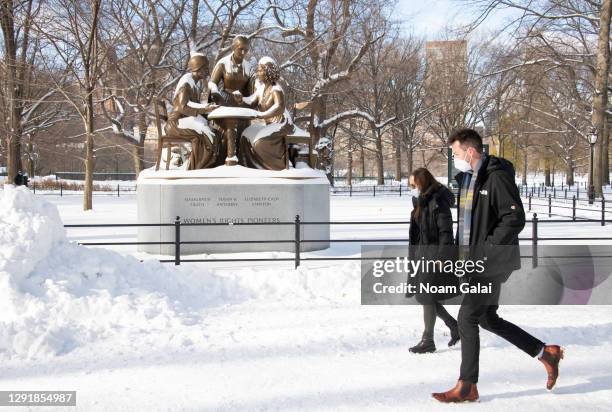 People walk by the Women’s Rights Pioneers monument honoring Susan B. Anthony, Sojourner Truth and Elizabeth Cady Stanton in Central Park during a...