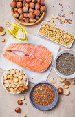 Omega 3 food sources and omega 6 on concrete background, top view copy space. Foods high in fatty acids including vegetables, seafood, nut and seeds