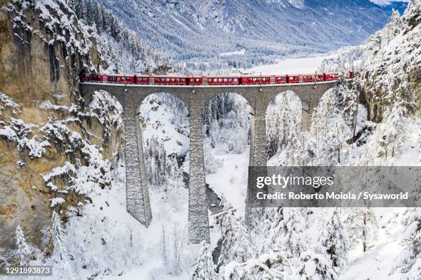 bernina express train on landwasser viaduct in winter, switzerland - winter wonder land stockfoto's en -beelden