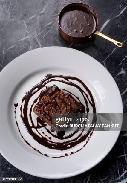 chocolate brownie with walnuts and chocolate sauce - brownie stock pictures, royalty-free photos & images