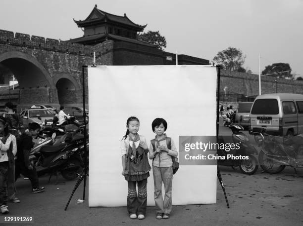 Huang Ying and Huang Xiaomeng pose for a photo in front of the Gate of Wuchang Uprising on the day marking the 100th anniversary of the Wuchang...