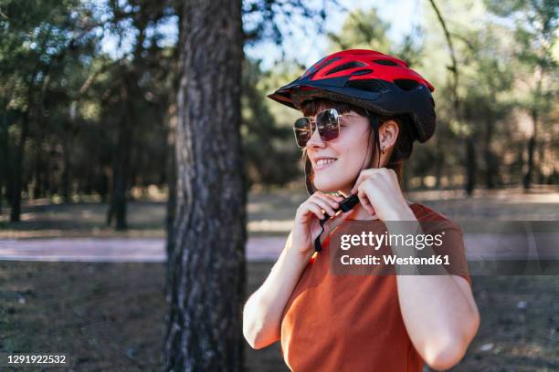 smiling young woman wearing cycling helmet - cycling helmet stock pictures, royalty-free photos & images