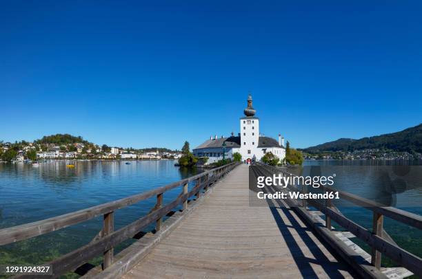 austria, upper austria, gmunden, clear summer sky over bridge leading toschloss ort - gmunden austria stock pictures, royalty-free photos & images