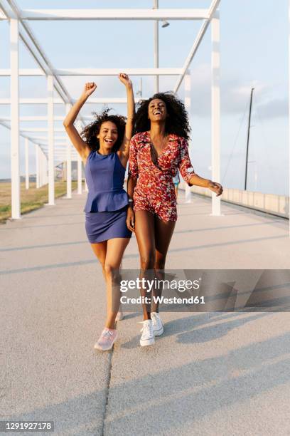 carefree young female friends walking - sommerkleid stock-fotos und bilder