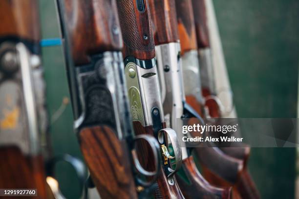 close up of group of shotguns in a rack. - jachtgeweer stockfoto's en -beelden