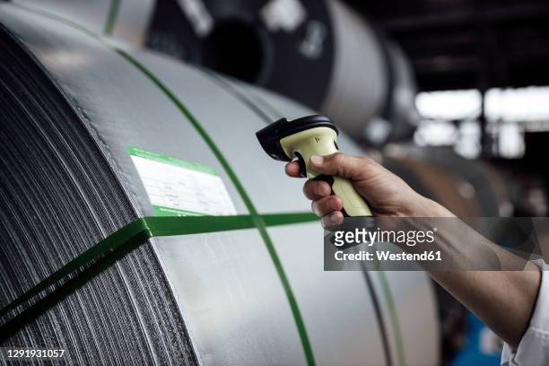 man's hand scanning barcode on steel rolls in industry - barcode scanner stock-fotos und bilder