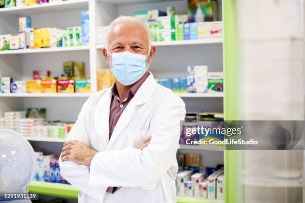 senior male pharmacist wearing a mask - pharmacy mask stock pictures, royalty-free photos & images