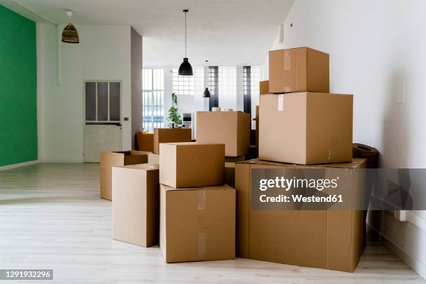 carboard boxes in living room of new house - moving box ストックフォトと画像