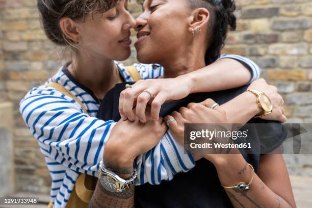 young lesbian couple doing romance while standing at back yard - gay couple in love stock pictures, royalty-free photos & images