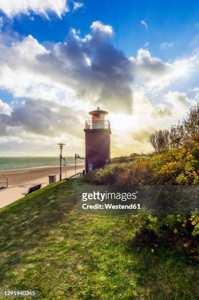 beach and lighthouse at sunset - foehr island photos et images de collection