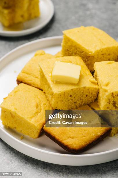 plate of golden cornbread squares - harina de maíz fotografías e imágenes de stock