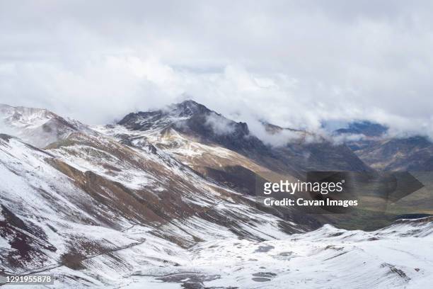 scenic view of valley in the andes on rainbow mountain trail during winter, pitumarca, peru - vinicunca photos et images de collection