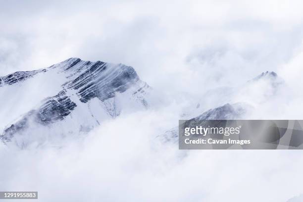 snowcapped mountain peaks in the andes covered with fog, rainbow mountain trail, pitumarca, peru - vinicunca fotografías e imágenes de stock