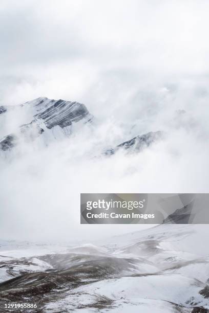 snowcapped mountain peaks in the andes covered with fog, rainbow mountain trail, pitumarca, peru - vinicunca photos et images de collection