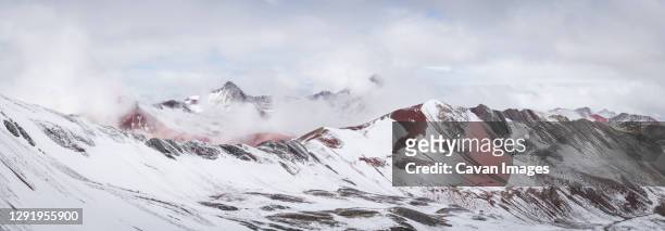 panoramic view of snow covered red valley seen from rainbow mountain trail, pitumarca, peru - vinicunca photos et images de collection