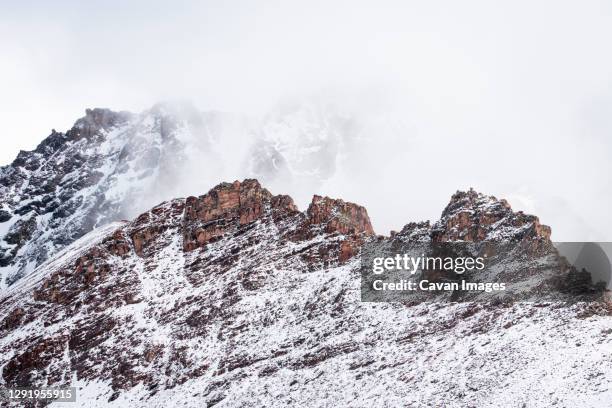 snowcapped mountain peaks in the andes covered with fog, rainbow mountain trail, pitumarca, peru - vinicunca fotografías e imágenes de stock